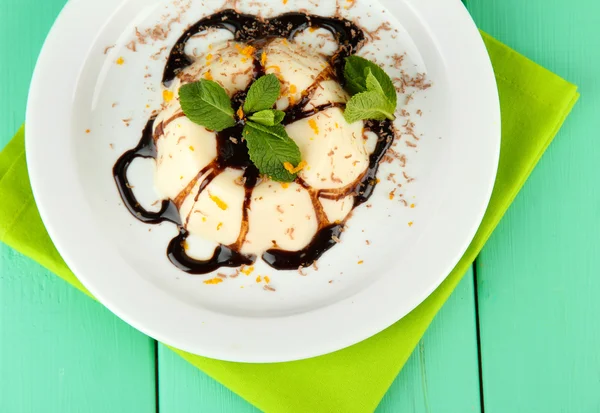 Panna cotta mit Schokoladensauce, auf farbigem Holzhintergrund — Stockfoto