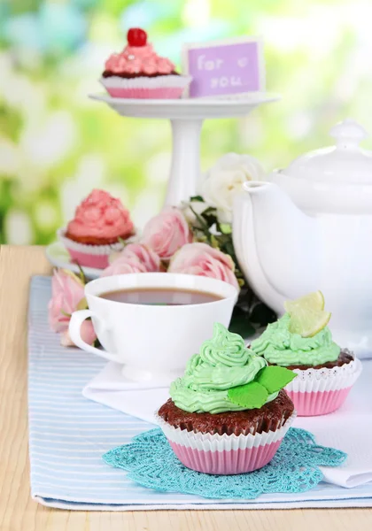 Bellissimi cupcake sul tavolo da pranzo su sfondo naturale — Foto Stock