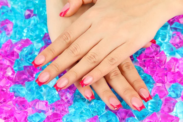 Closeup of hands of young woman with elegance manicure on bright background — Stock Photo, Image