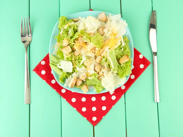 Ensalada César sobre plato azul, sobre fondo de madera color — Foto de Stock