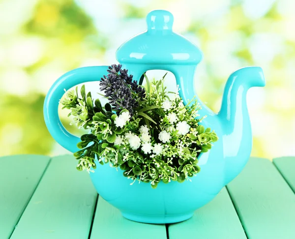 Pot with flowers on a wooden table on the nature background — Stock Photo, Image