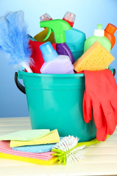 Produtos de limpeza em balde sobre fundo de cor — Fotografia de Stock