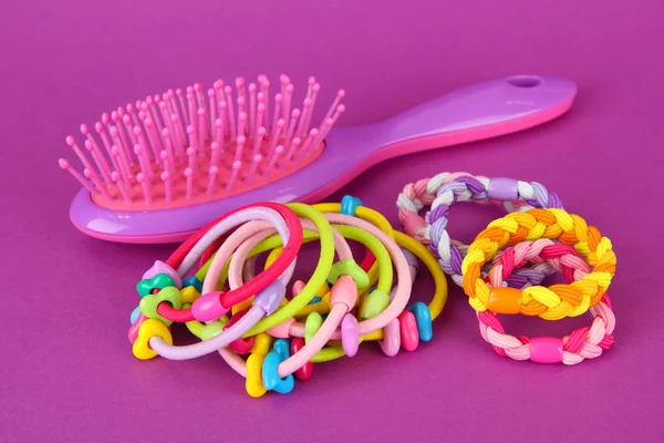 Scrunchies, haarborstel en haar - klem op een roze achtergrond — Stockfoto