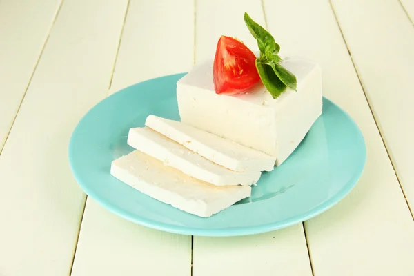 Sheep milk cheese, with basil and tomato on color wooden background — Stock Photo, Image