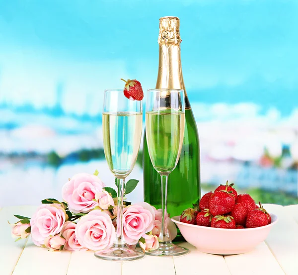 Parlak zemin üzerine şampanya, çilek ve pembe Güllü romantik natürmort — Stok fotoğraf