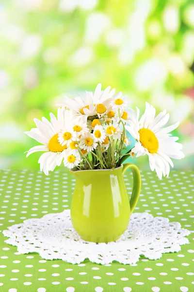 Bellissime camomille bouquet in brocca su tovaglia su sfondo naturale — Foto Stock