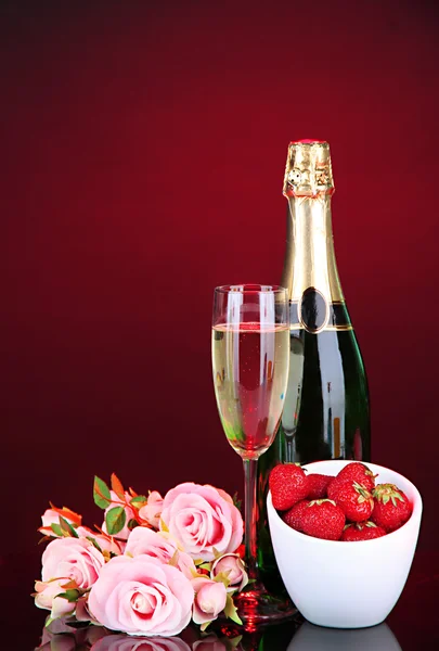 Bodegón romántico con champán, fresa y rosas rosadas, sobre fondo de color oscuro — Foto de Stock