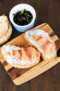 ahşap masa üzerinde kesme tahtası üzerinde balık sandviç