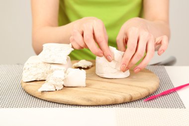 Kil heykel, gri arka plan üzerinde çalışan genç güzel kadın