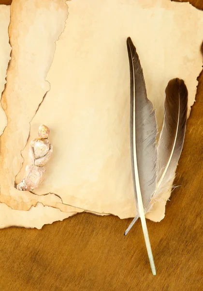 Papel viejo con figurilla, sobre fondo de madera — Foto de Stock