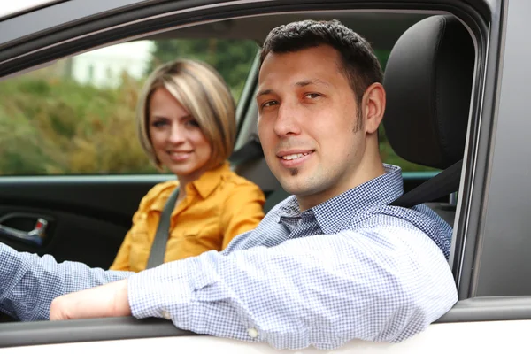 Retrato de jovem casal bonito sentado no carro — Fotografia de Stock