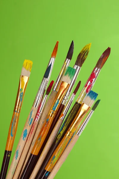 Many brush in paint on green background — Stock Photo, Image