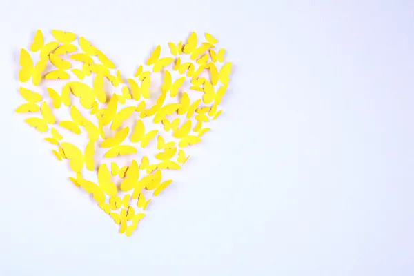 Бумажная желтая бабочка в форме сердца на стене — стоковое фото
