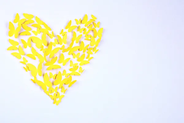 Paper yellow butterfly in form of heart on wall — Stock Photo, Image