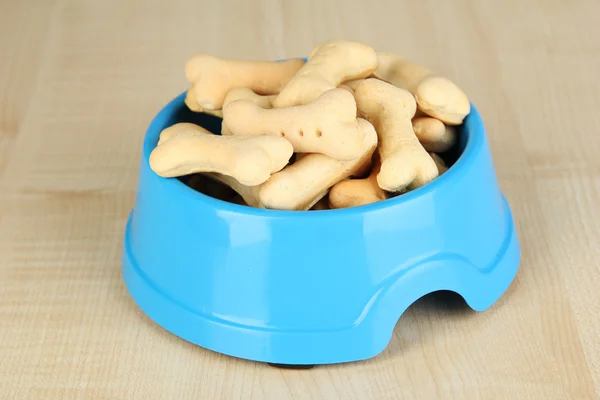 Comida seca para perros en un tazón sobre fondo de madera — Foto de Stock