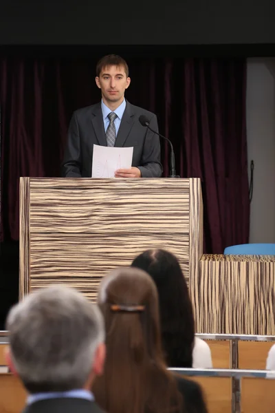 Un homme d'affaires prononce un discours dans une salle de conférence — Photo