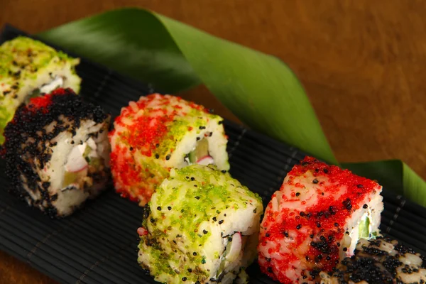 Tasty Maki sushi - Roll on mat on brown background — Stock Photo, Image