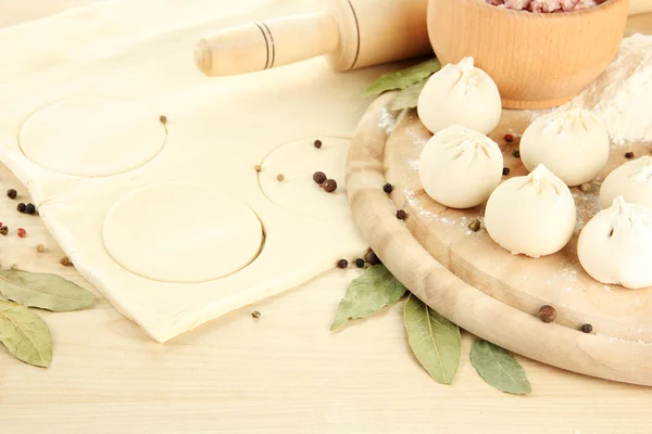 Raw dumplings and dough, on wooden table — Stock Photo, Image