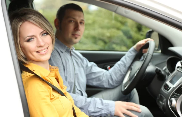 Retrato de jovem casal bonito sentado no carro — Fotografia de Stock