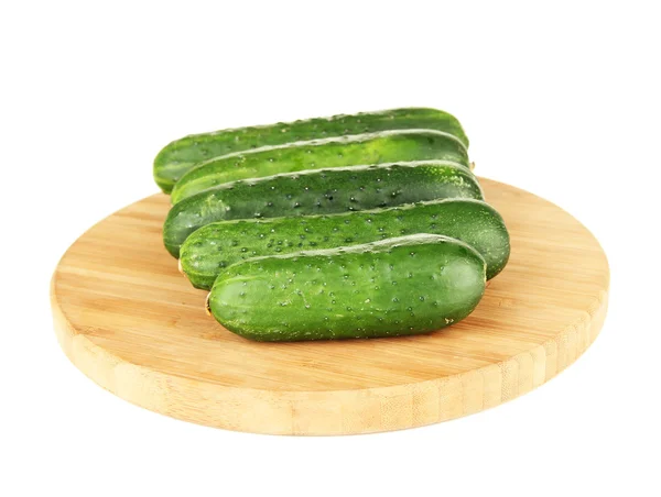 Smakelijke groene komkommers op houten snijplank, geïsoleerd op wit — Stockfoto