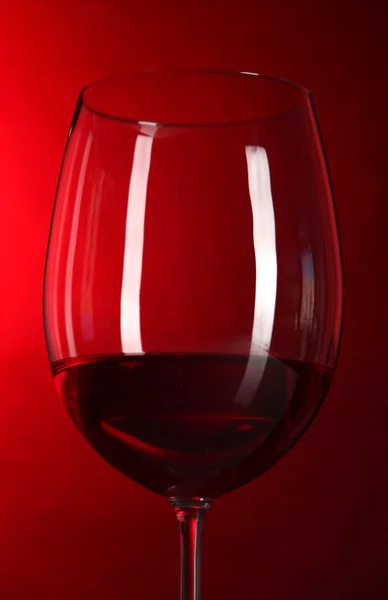 Glass of wine on bright red background — Stock Photo, Image