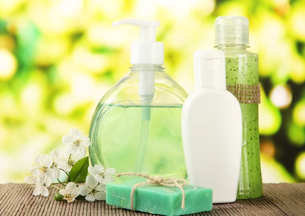 Cosmetics bottles and natural handmade soap on green background — Stock Photo, Image