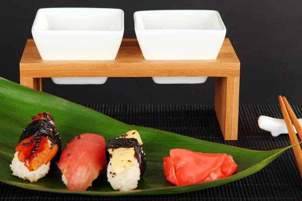 Smakelijke maki sushi - roll op het groene blaadje op grijze achtergrond — Stockfoto