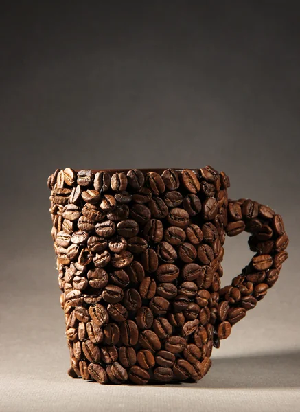 Xícara de grãos de café, em fundo cinza — Fotografia de Stock