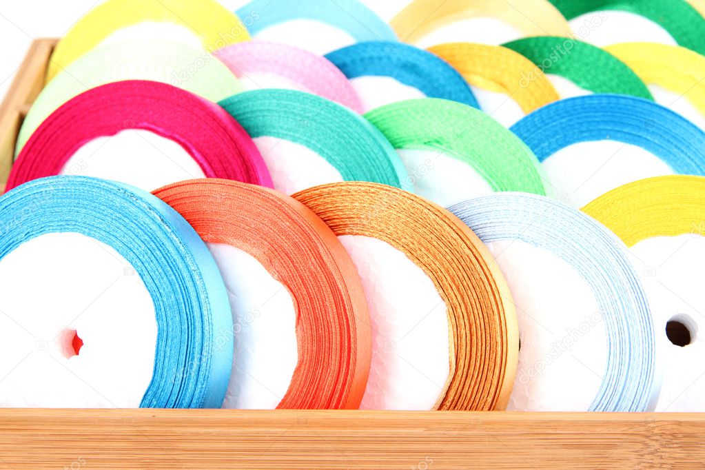 Bright silk ribbons in wooden box, close up