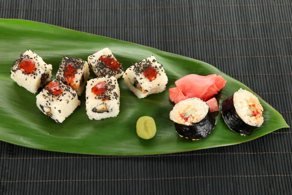 Pyszne maki sushi - rolki na zielony liść na drewniany stół szczegół — Zdjęcie stockowe