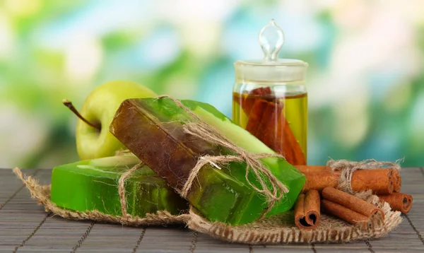 Handgemaakte zeep en ingrediënten voor zeep maken op bamboe mat, op groene achtergrond — Stockfoto