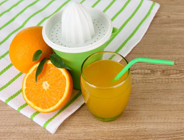 柑橘類を押して、ジュースと熟したオレンジ茶色の木製のテーブルの上のガラス — ストック写真