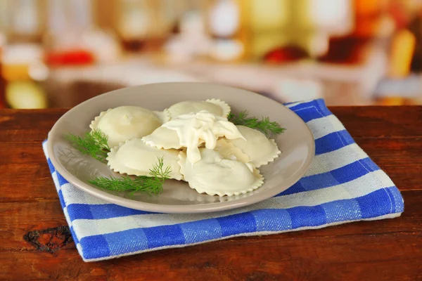 Tasty dumplings on plate, on wooden table — Stock Photo, Image