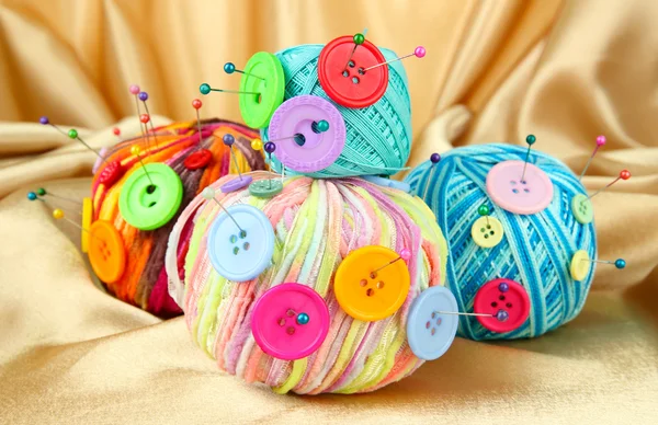 Colorful buttons and multicolor wool balls, on color fabric background — Stock Photo, Image