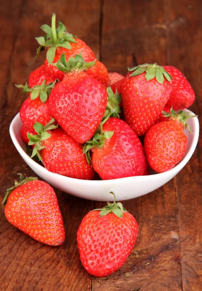 Fresh strawberry in bowl on wooden background — Stock Photo, Image