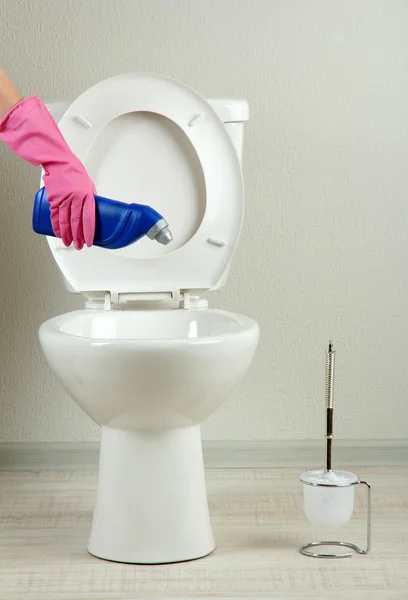 Frau Hand mit Sprühflasche reinigt Toilettenschüssel im Badezimmer — Stockfoto
