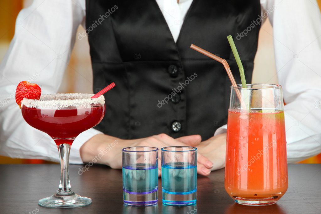 Barmen making tasty cocktails, on bright background