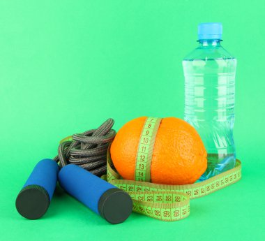 ölçme bant, ip ve şişe suyu, renkli arka plan üzerinde atlama ile turuncu