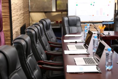 Empty conference room with laptops on table clipart