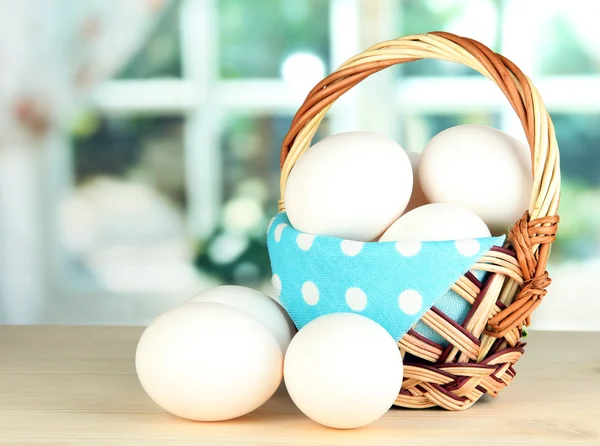 Muchos huevos en la cesta en la mesa en la habitación —  Fotos de Stock