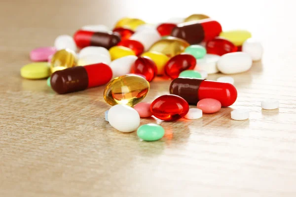 Assortment of pills, tablets and capsules on wooden table — Stock Photo, Image