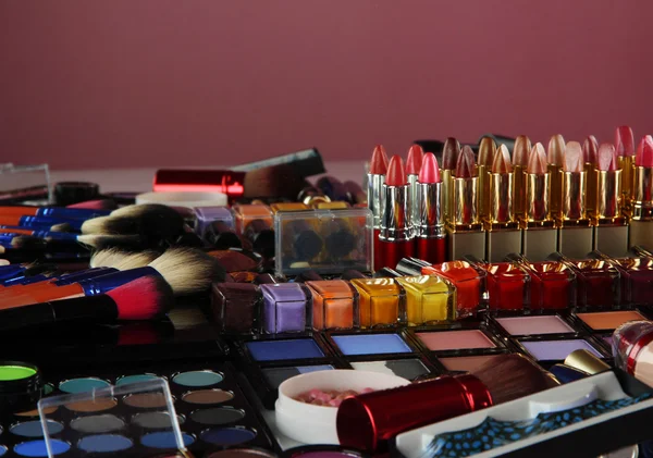 Багато різних косметичних засобів на фіолетовому фоні — стокове фото