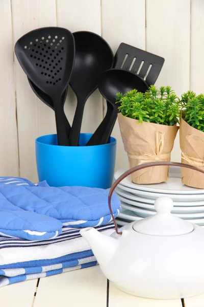 Nastavení kuchyně: nádobí, chňapky, ručníky a jinde na dřevěný stůl — Stock fotografie