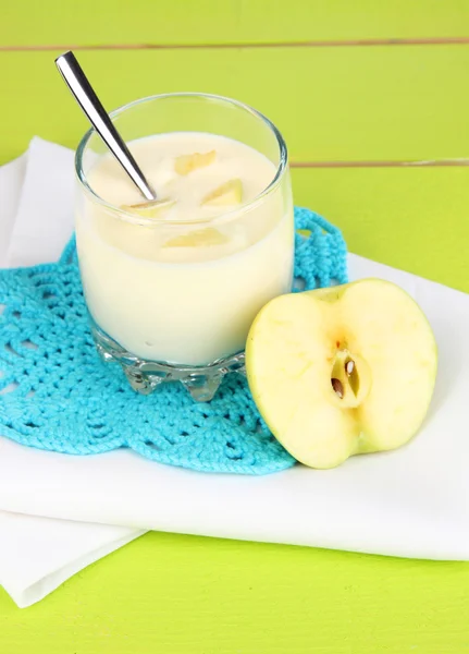 Delicious yogurt in glass with apple on blue tablecloth — Stock Photo, Image