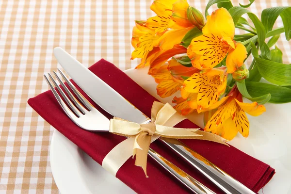 Nastavení slavnostní jídelní stůl s květinami na pestrou pozadí — Stock fotografie