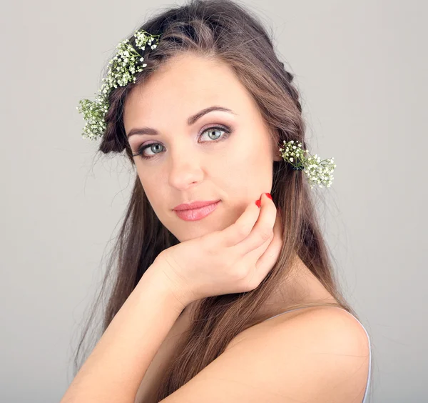 Jovem com belo penteado e grinalda em fundo cinza — Fotografia de Stock