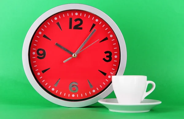 Cup coffee and clock on green background — Stock Photo, Image