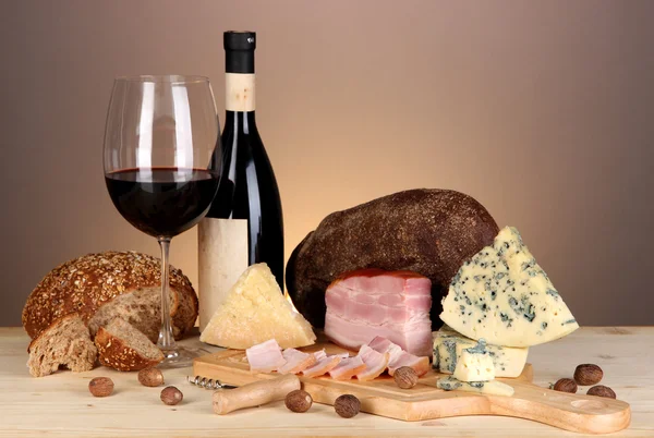 Exquisito bodegón de vino, queso y productos cárnicos — Foto de Stock