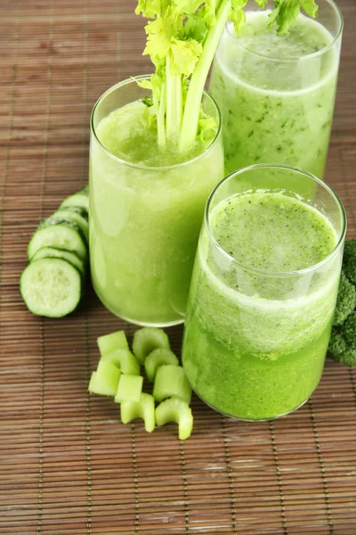 Glasses of green vegetable juice on bamboo mat — Stock Photo, Image