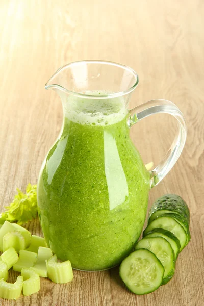 Glass pitcher of green vegetable juice on wooden background — Stock Photo, Image